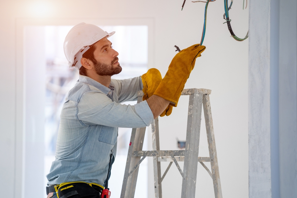 Electrician,working,on,building,site,repairing,light,at,home,repair,work.
